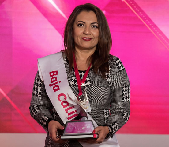 Petra Godoy ganadora del Premio Emprendedores 2024, sosteniendo el trofeo en un restaurante.